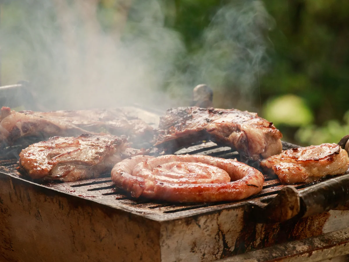 An outdoor grill with meats and sausages as a serving reference for the Backyard BBQ Box